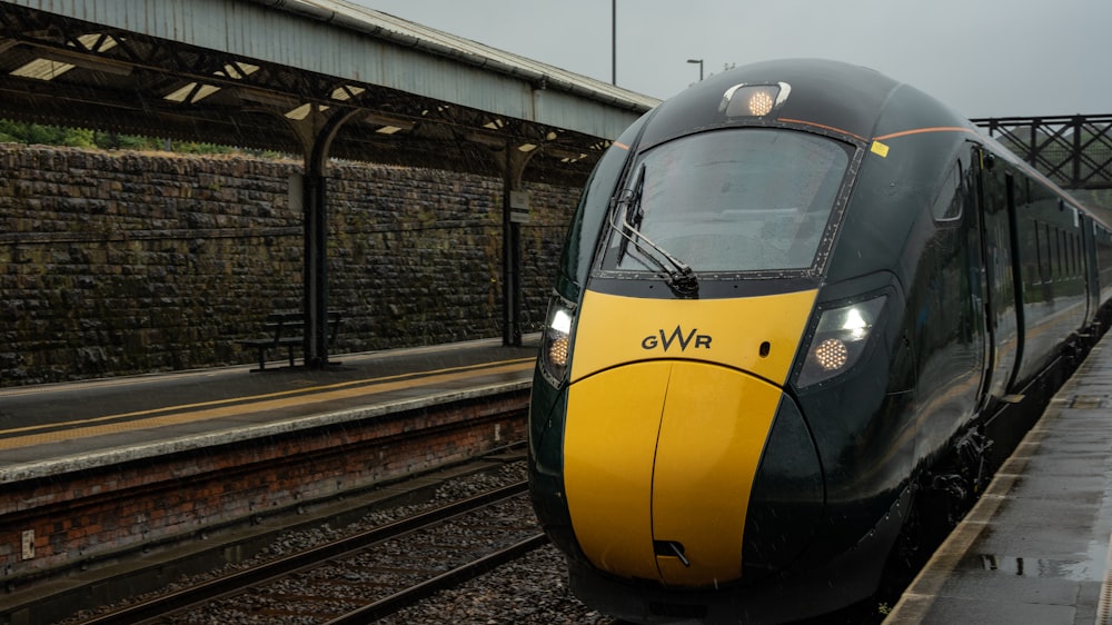 a yellow and black train traveling down train tracks