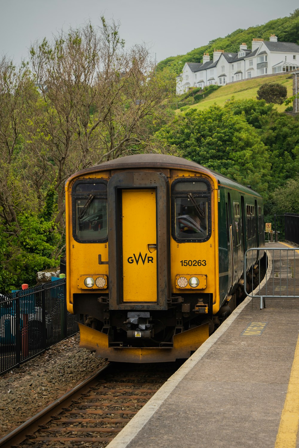 a yellow train pulling into a train station