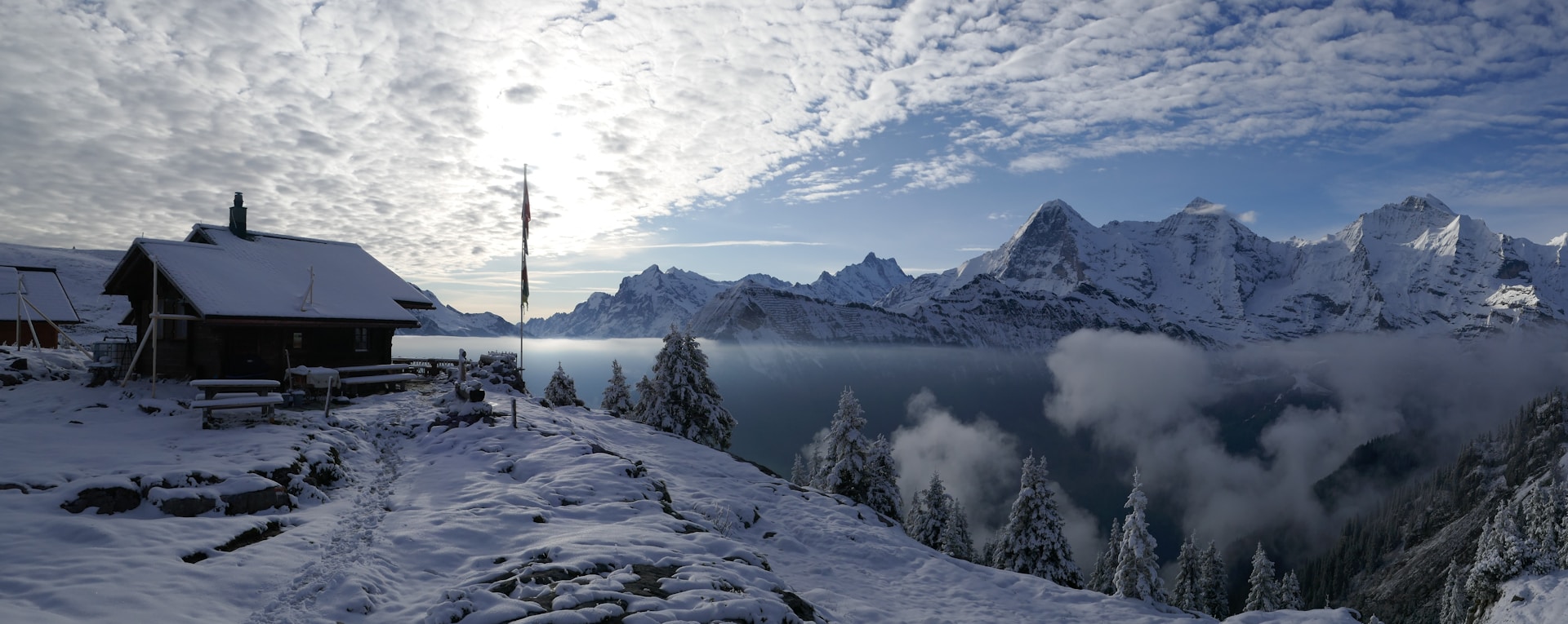 a snow covered mountain with a cabin in the foreground