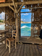 Interior of a nature beach hut featuring rustic wooden furniture and soft natural lighting.