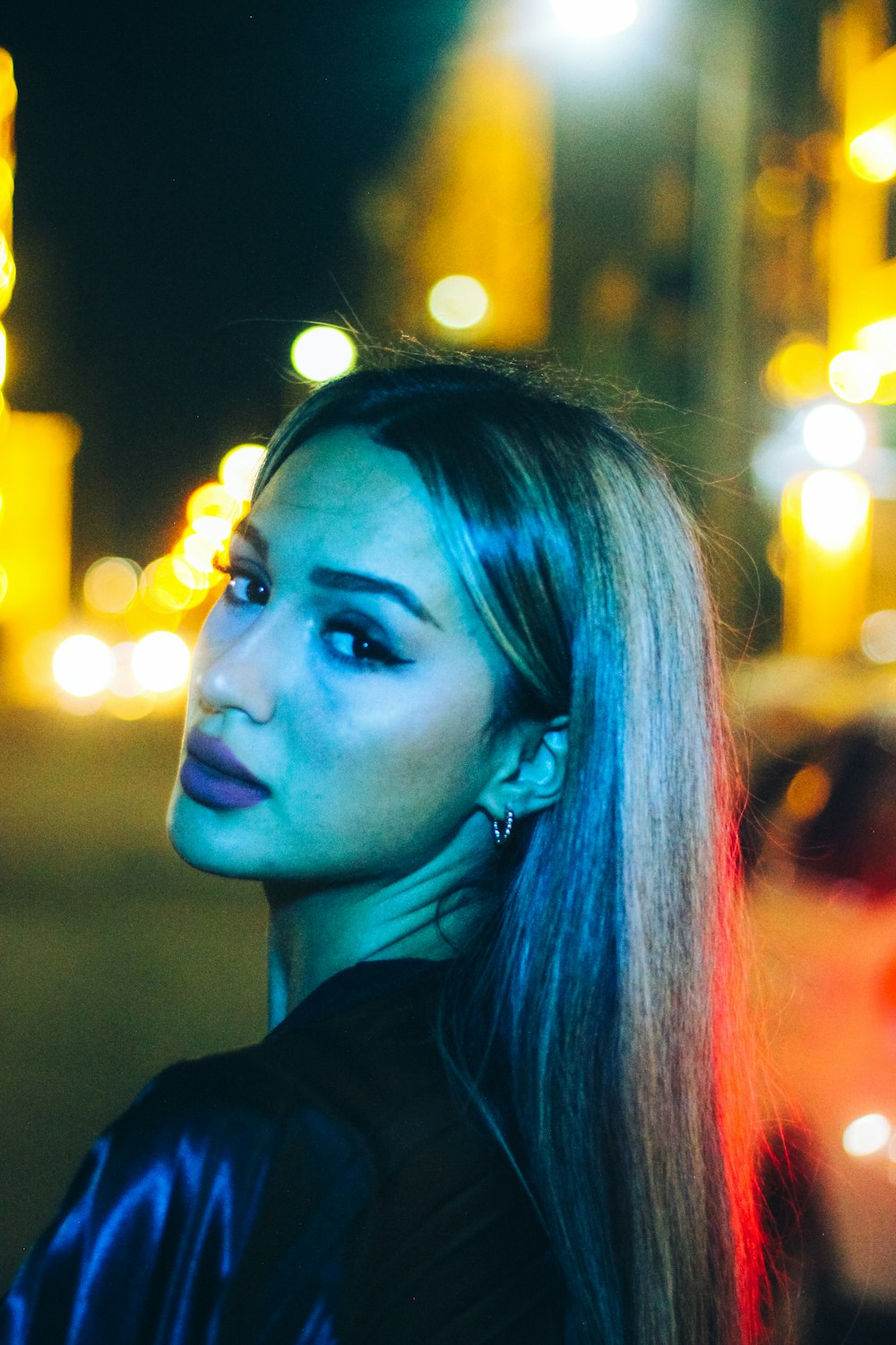 a woman standing in the street at night