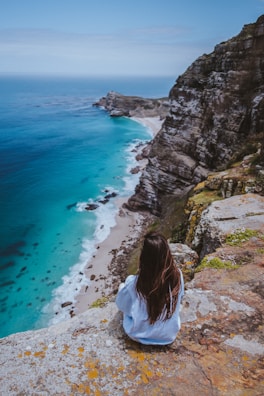 A traveler gazing at a breathtaking view from a cliff.