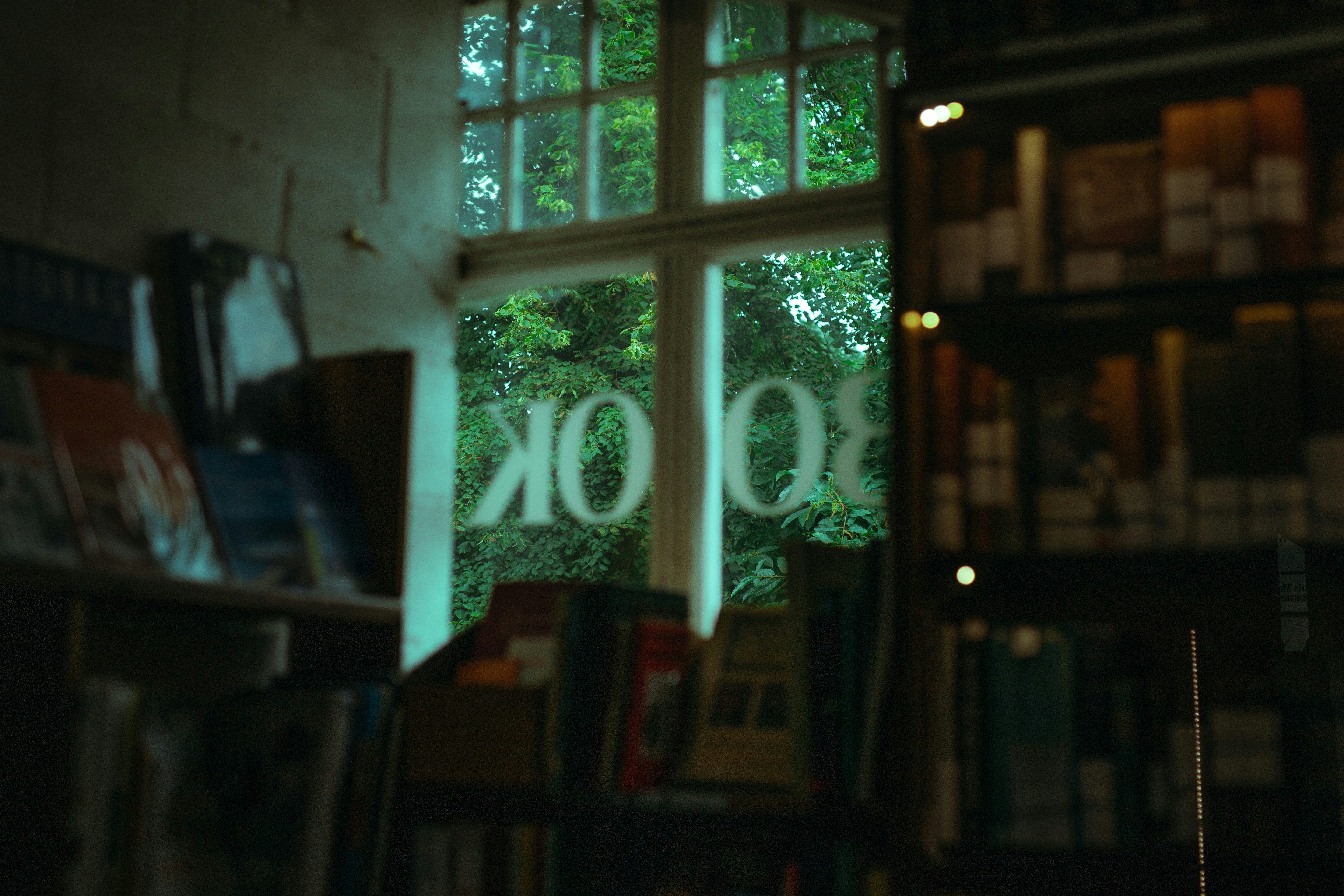 a bookshelf filled with lots of books next to a window