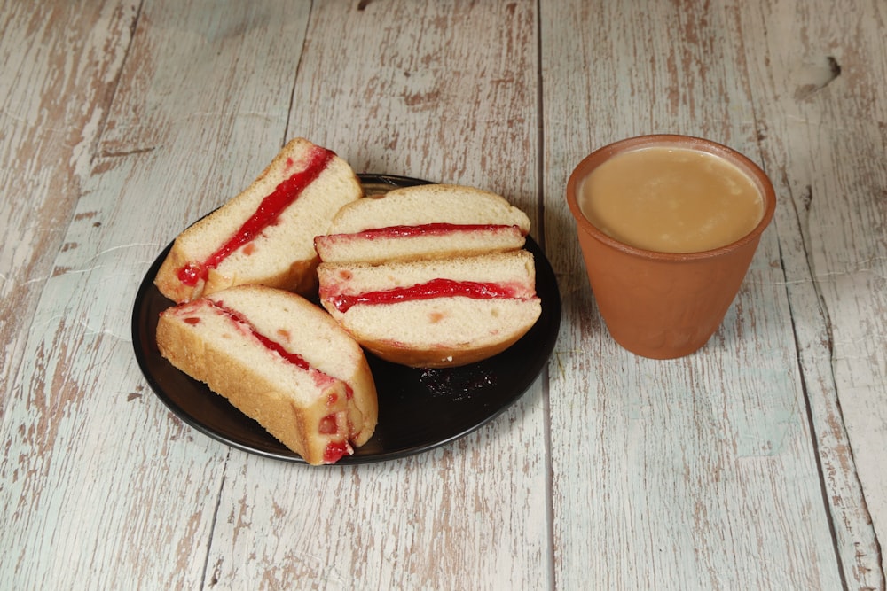 a plate of jelly sandwiches next to a cup of coffee