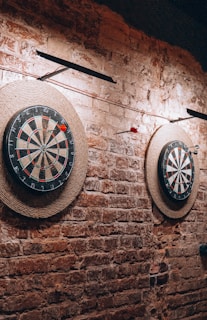 a brick wall with two darts and a dart on it