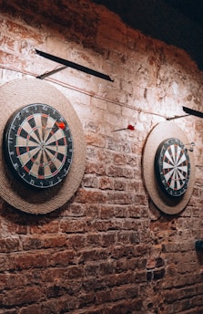 a brick wall with two darts and a dart on it