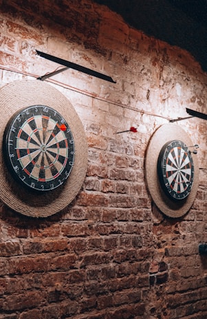 a brick wall with two darts and a dart on it