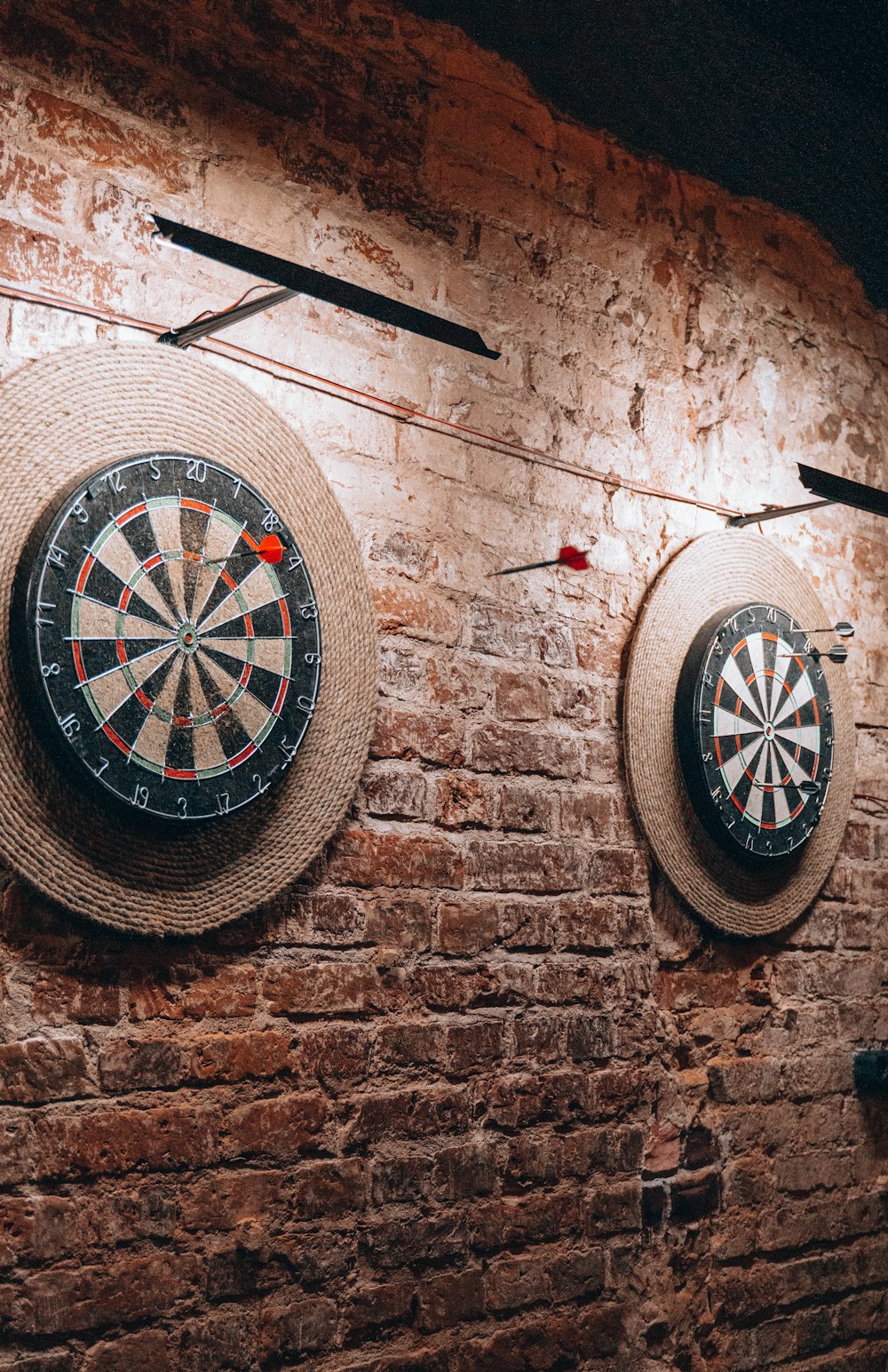 a brick wall with two darts and a dart on it