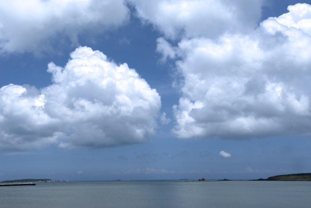 una gran masa de agua bajo un cielo azul nublado
