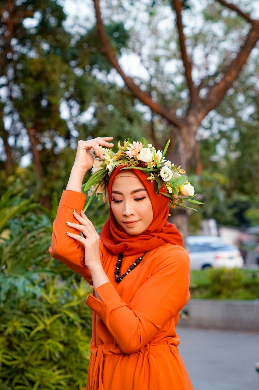 a woman wearing an orange hijab and a flower crown