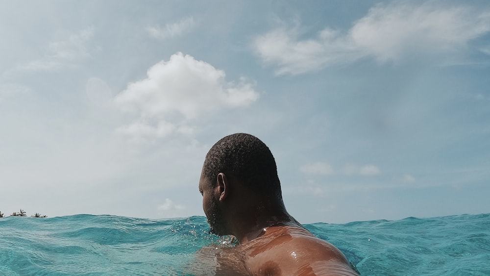 a man swimming in the ocean on a sunny day