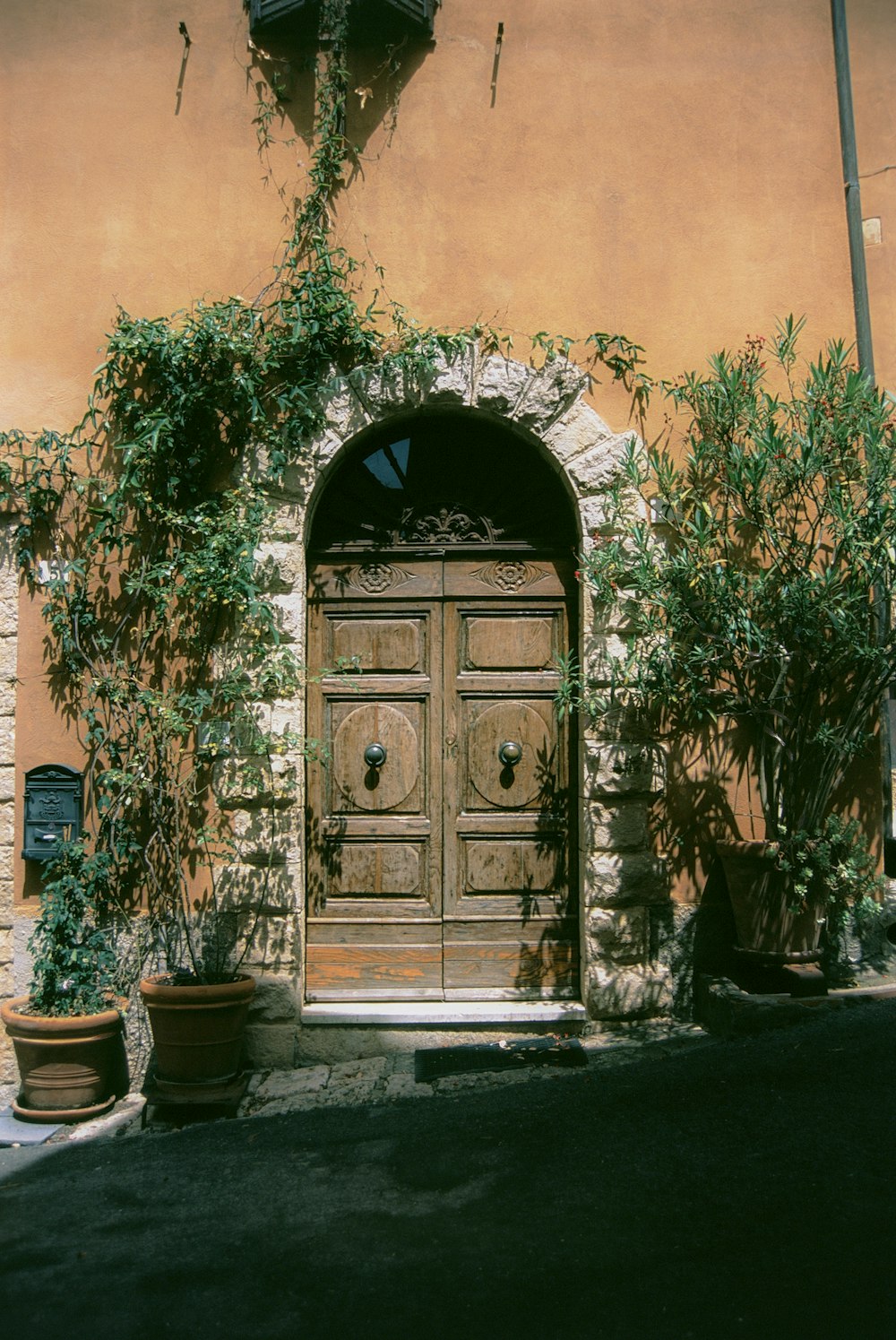 a building with a wooden door and a clock on the side of it