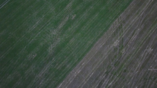 Aerial view of fertile farmland with visible soil layers and crop patterns.