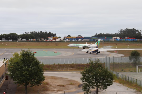 Airplane taking off from Félix Houphouët-Boigny airport with cargo containers in foreground.