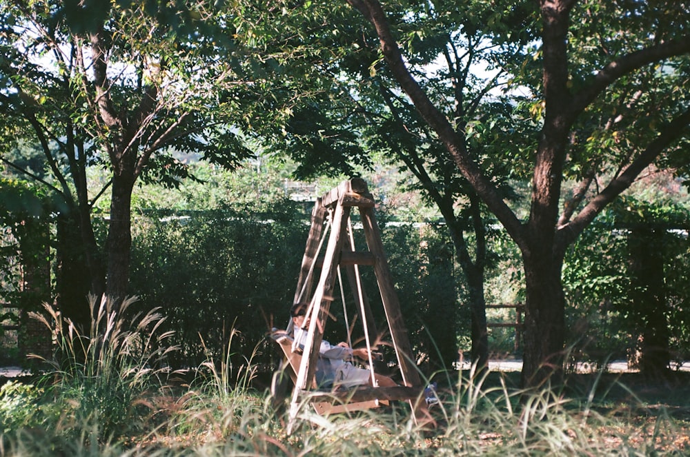a man sitting in a chair under a tree