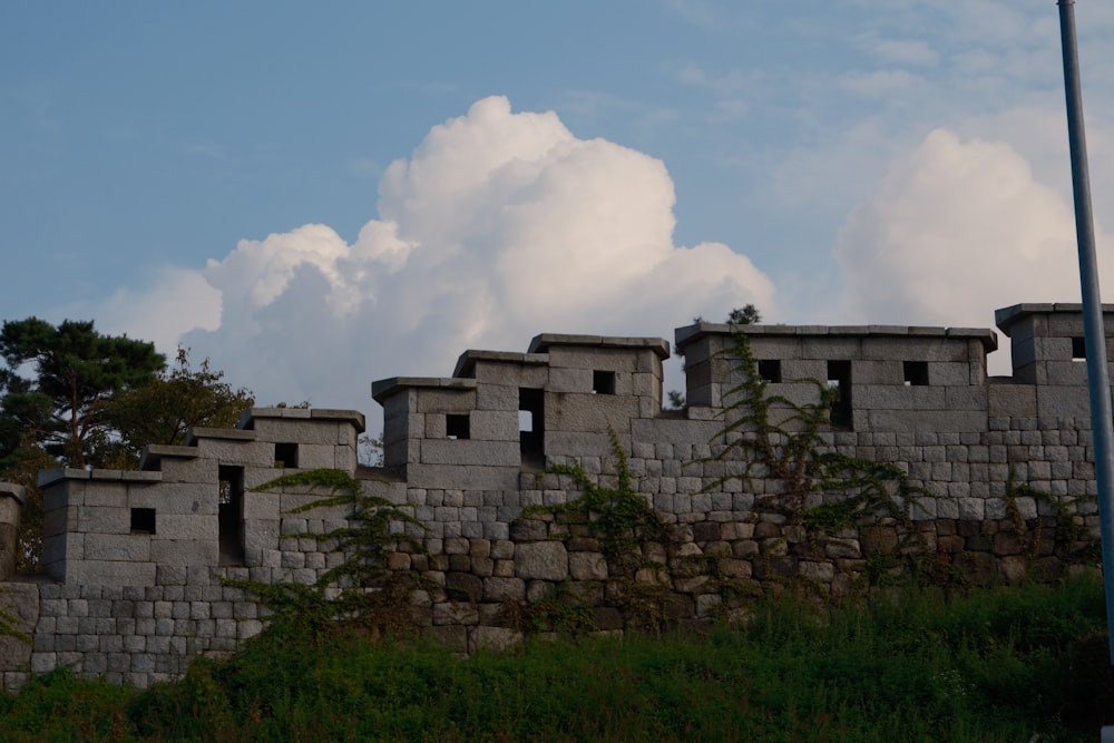 a stone wall with a clock tower in the background