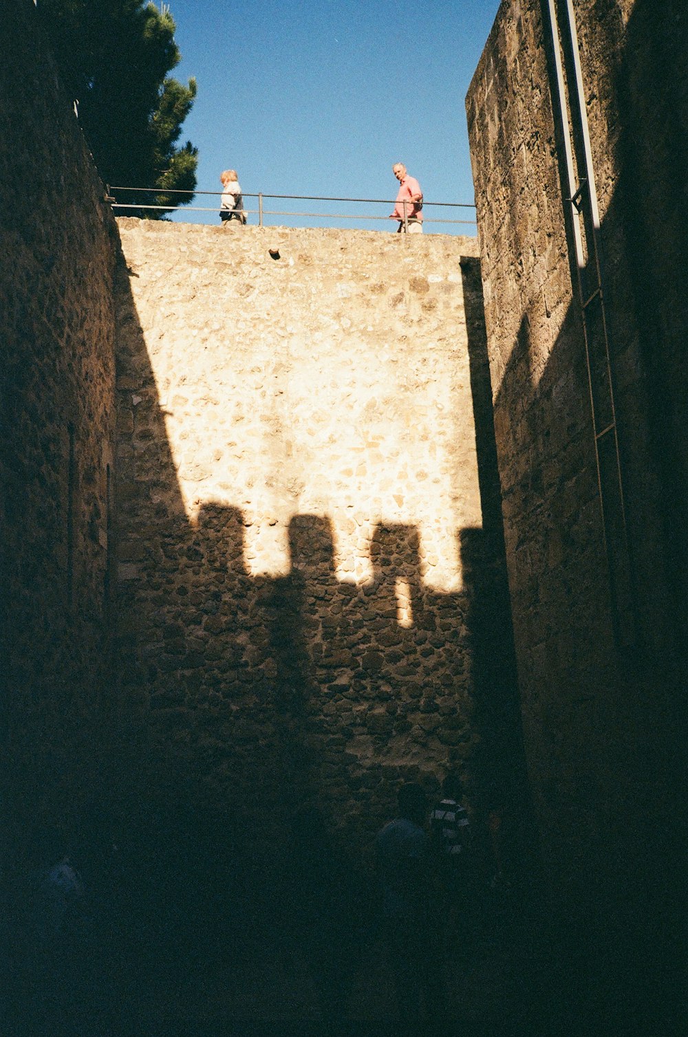 a shadow of people walking up a hill