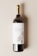A wine bottle with a gold foil cap and a cream-colored label featuring an illustration of an owl. The label text reads 'An Elegant Wine.' The background is a neutral, soft beige color.