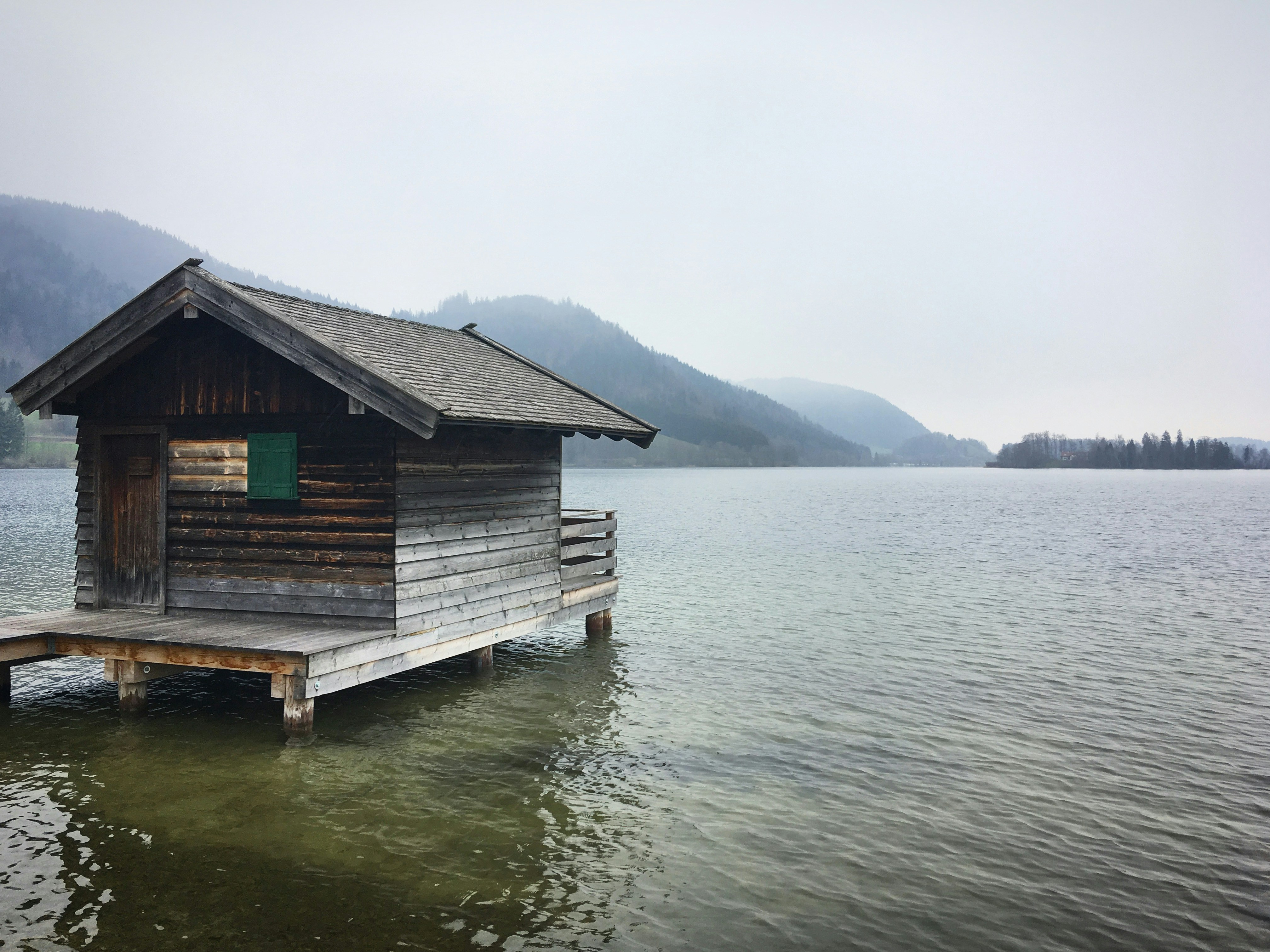 a small wooden cabin sitting on top of a body of water