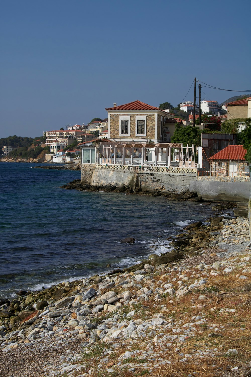 a rocky shore with houses and a body of water