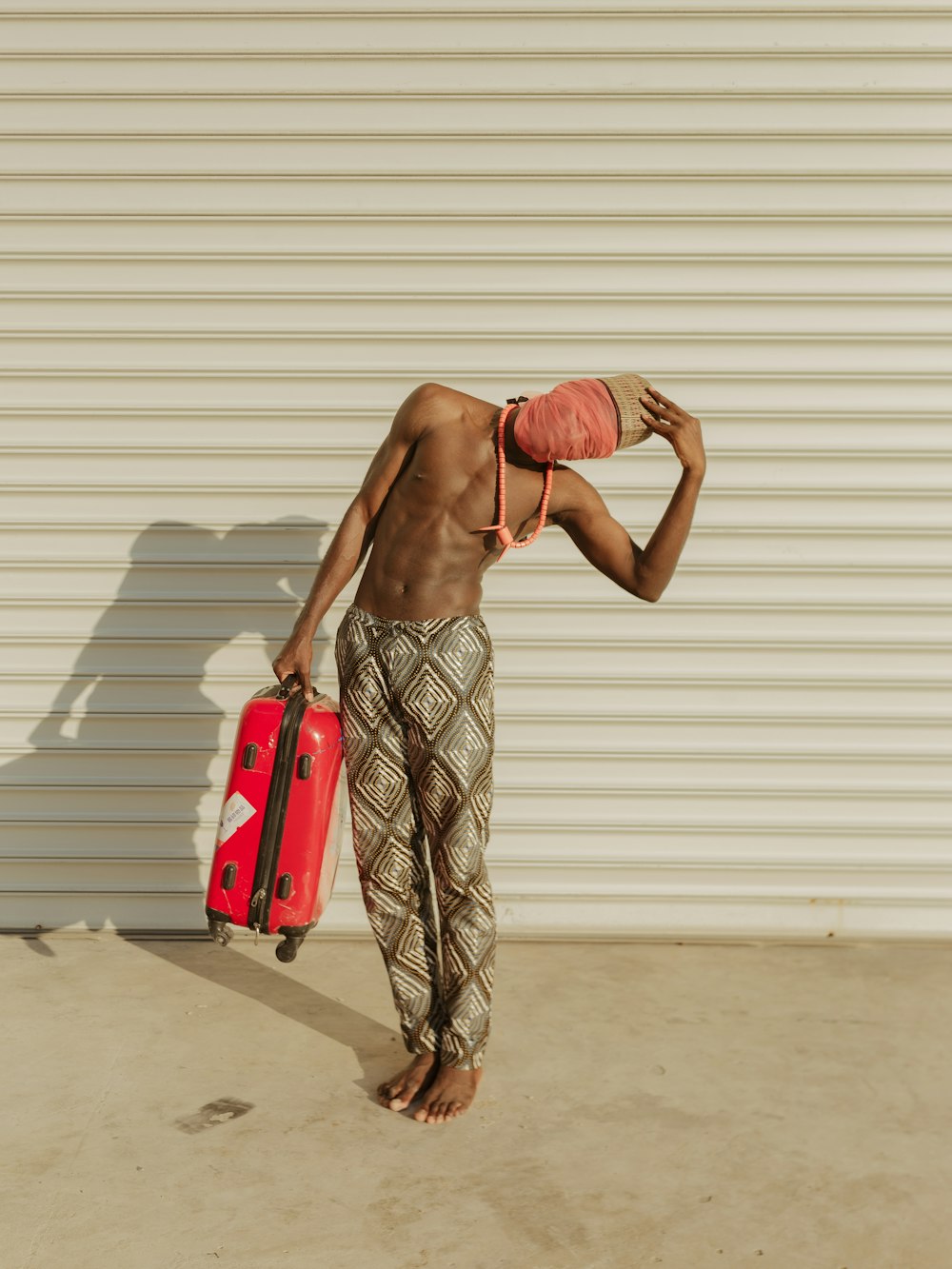 a man holding a red suitcase and a red bag