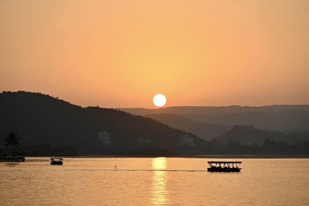 a sunset over a body of water with boats in it