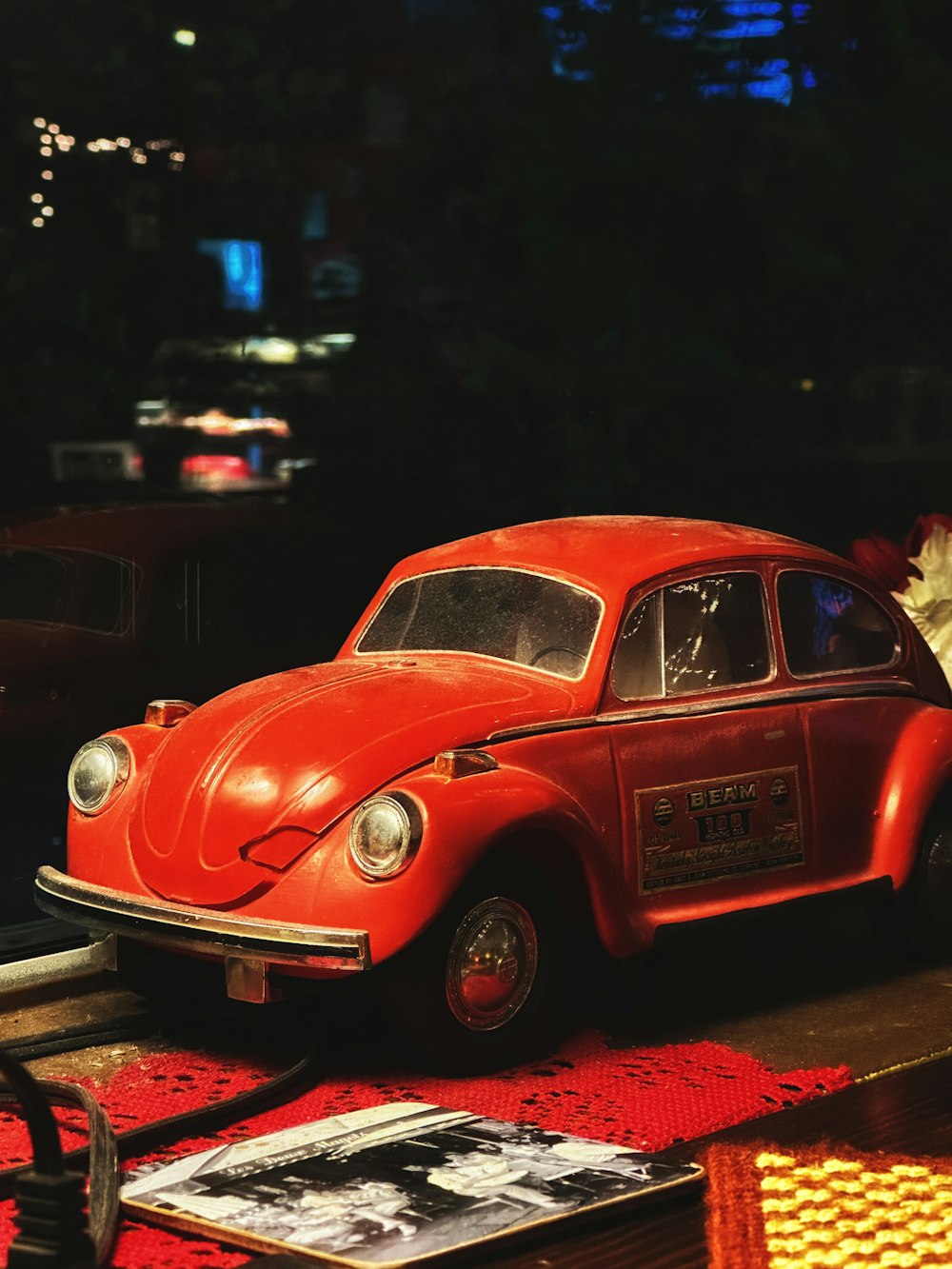 a red toy car sitting on top of a table