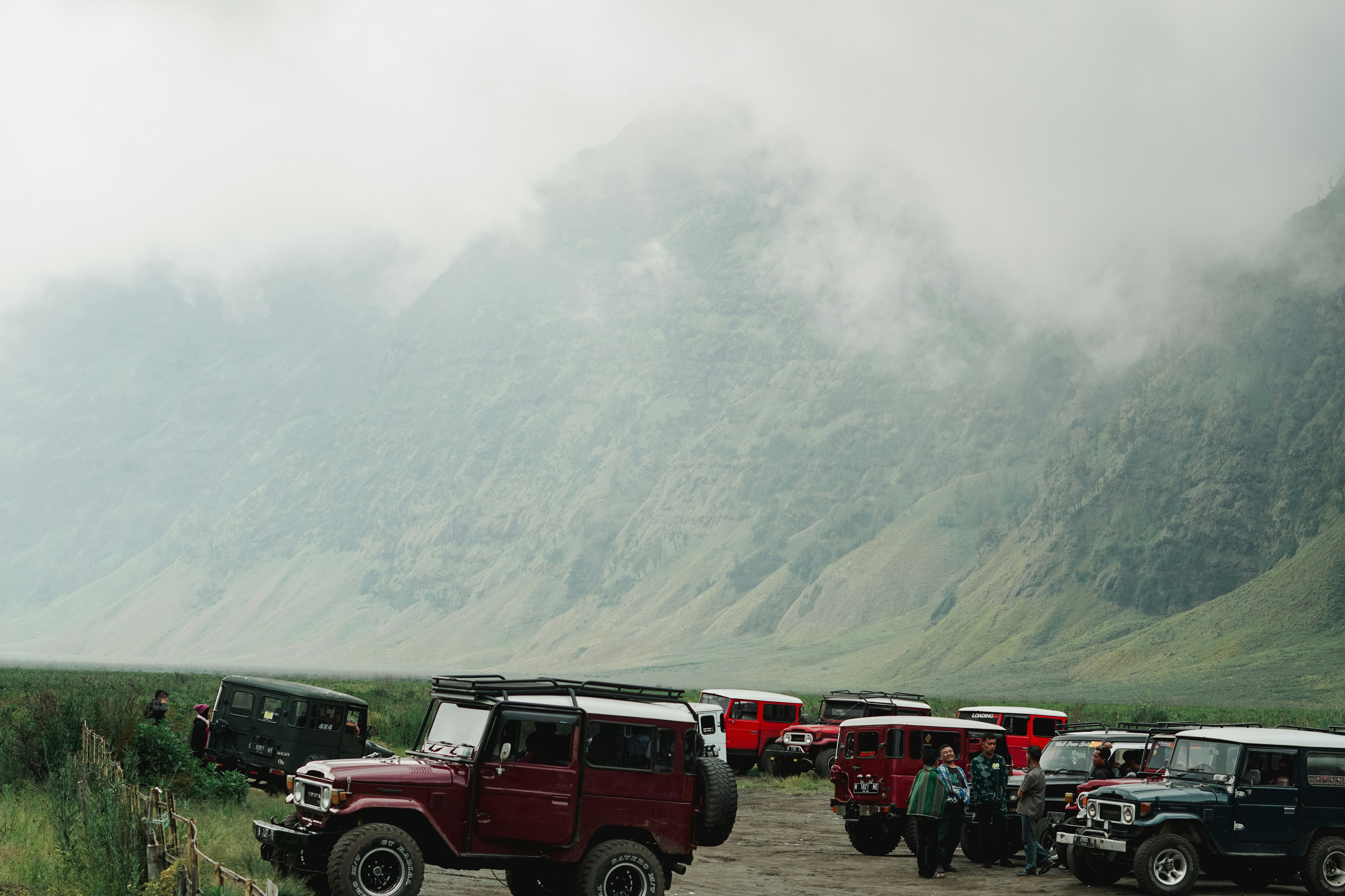 a group of jeeps parked in front of a mountain