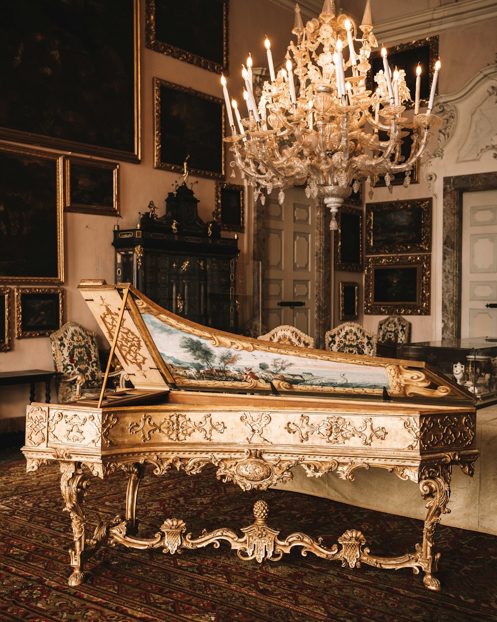 a grand piano sitting in a room with a chandelier