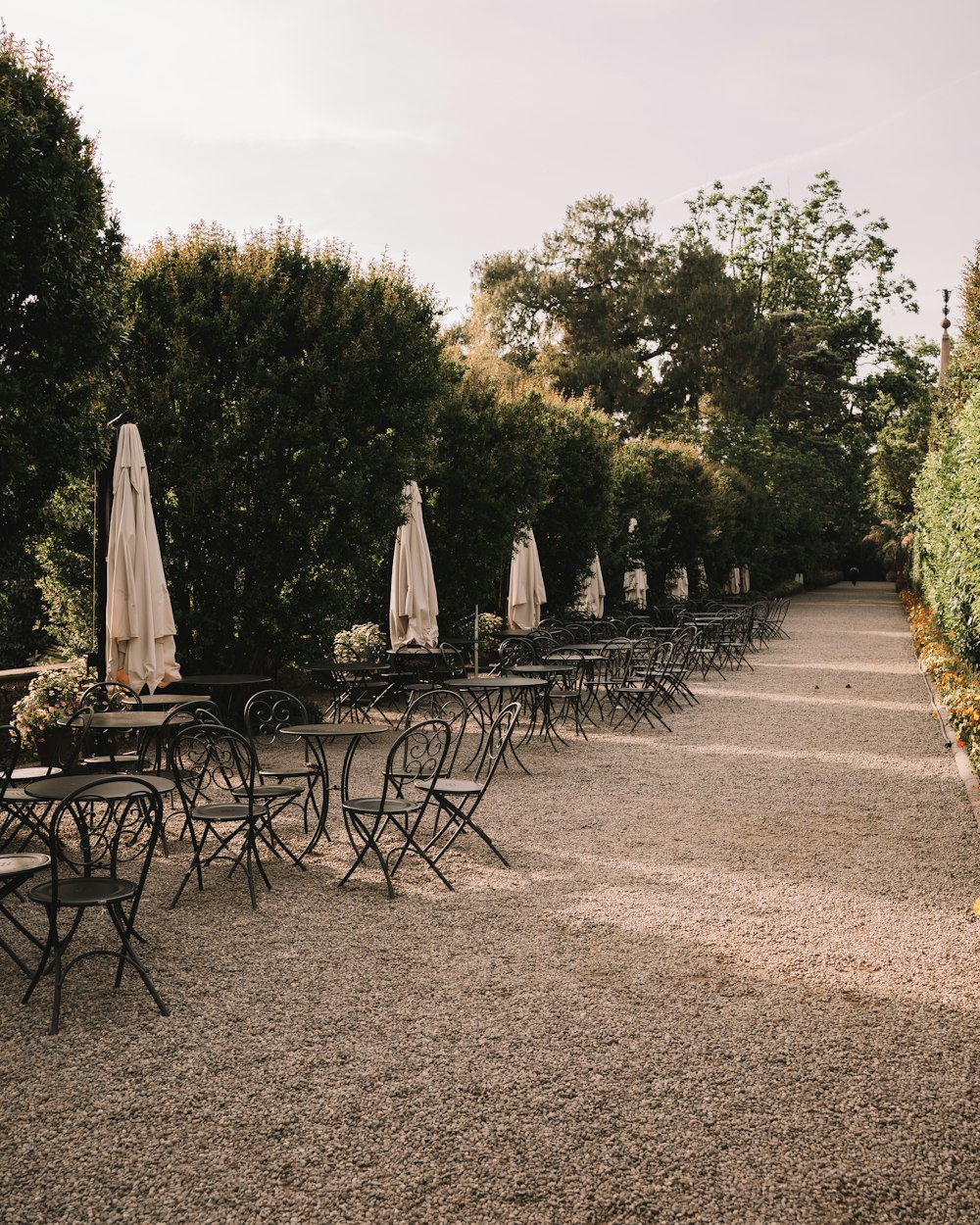 a row of tables and chairs with umbrellas on them