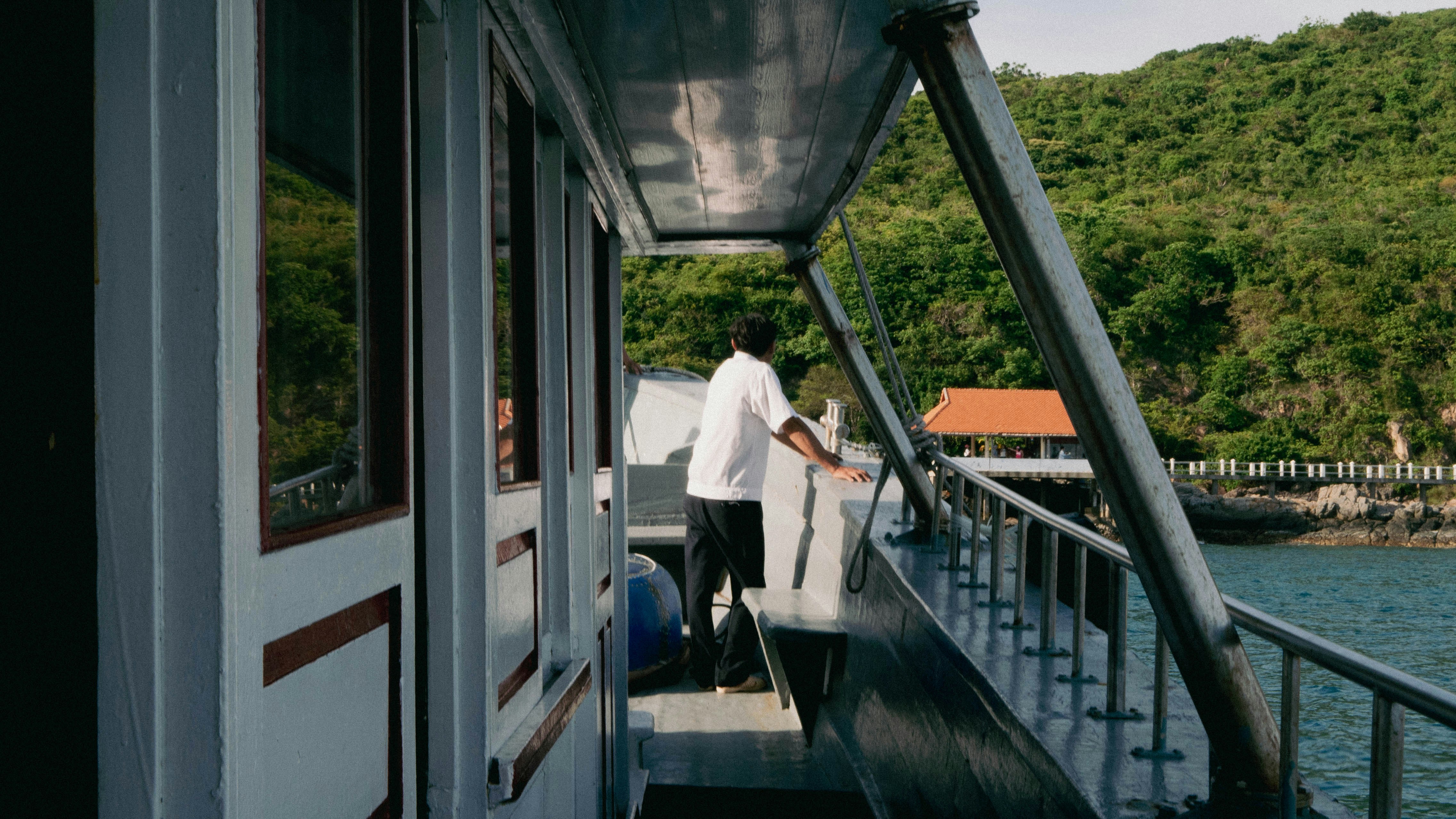 a man walking across a bridge next to a body of water