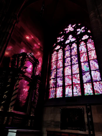 Majestic stained glass window casting colorful light inside a grand church.