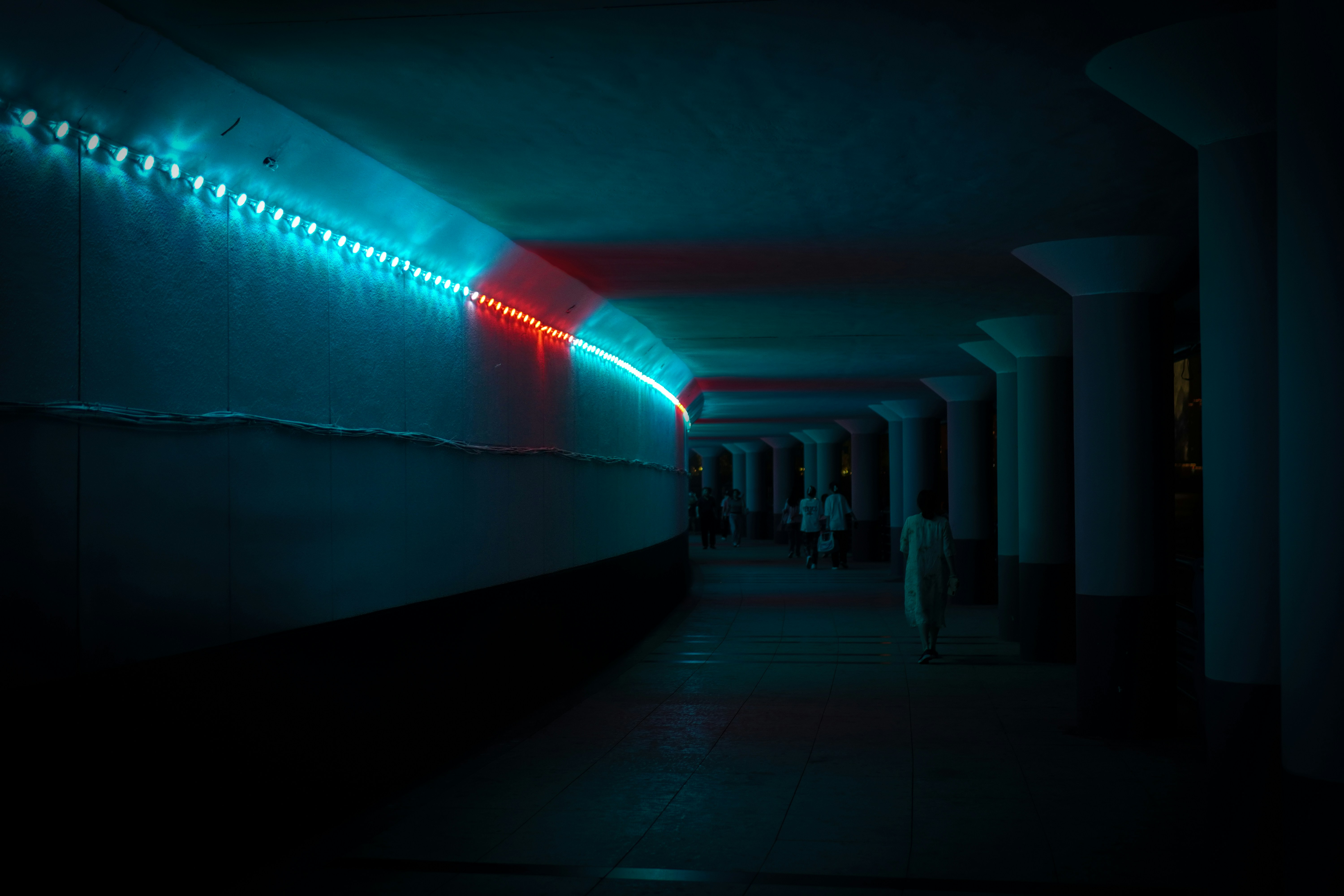 a long hallway with a neon light on the wall