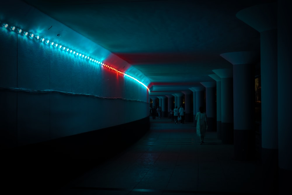 a long hallway with a neon light on the wall