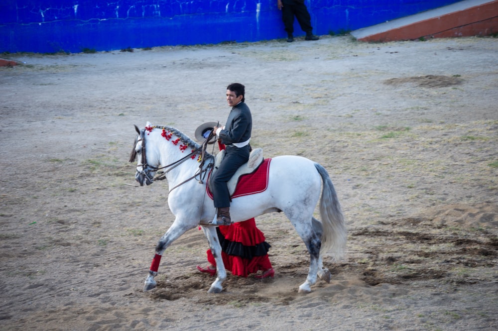 a man riding on the back of a white horse