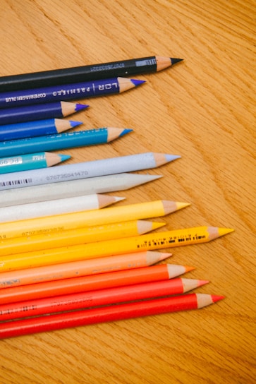 A colorful assortment of pencils arranged neatly on a wooden desk.