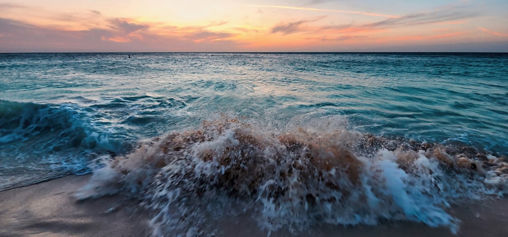 a beach with a wave coming in to the shore