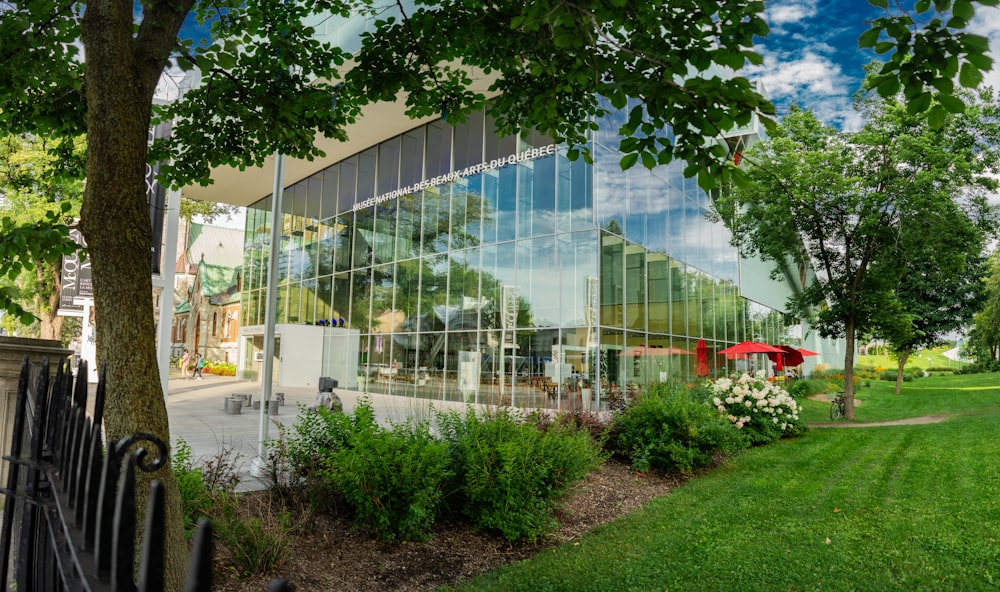 a large glass building with a red umbrella in front of it