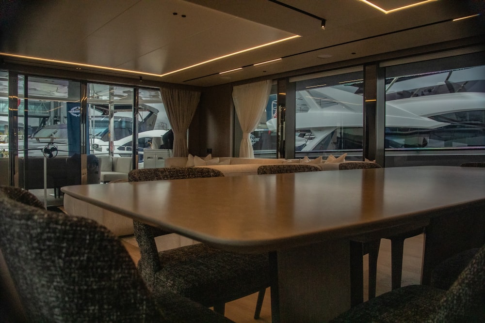 a large wooden table in a room with lots of windows