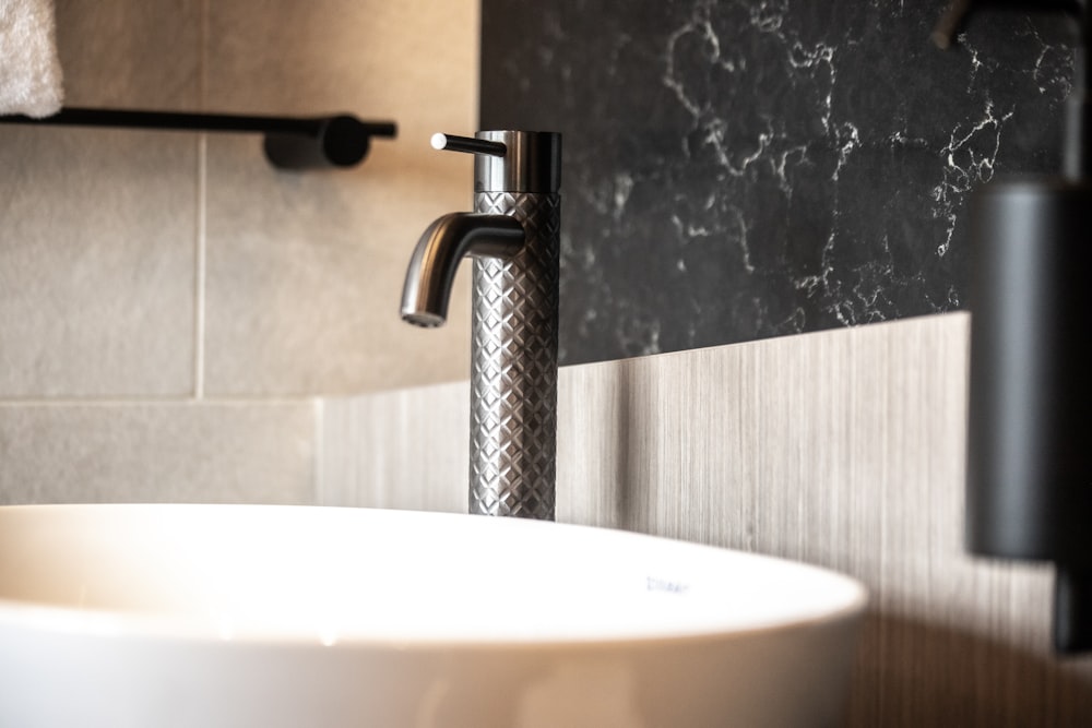 a white sink sitting under a bathroom faucet