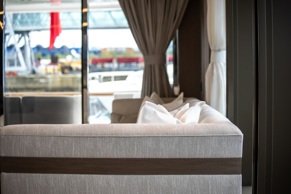 a white couch sitting in front of a window