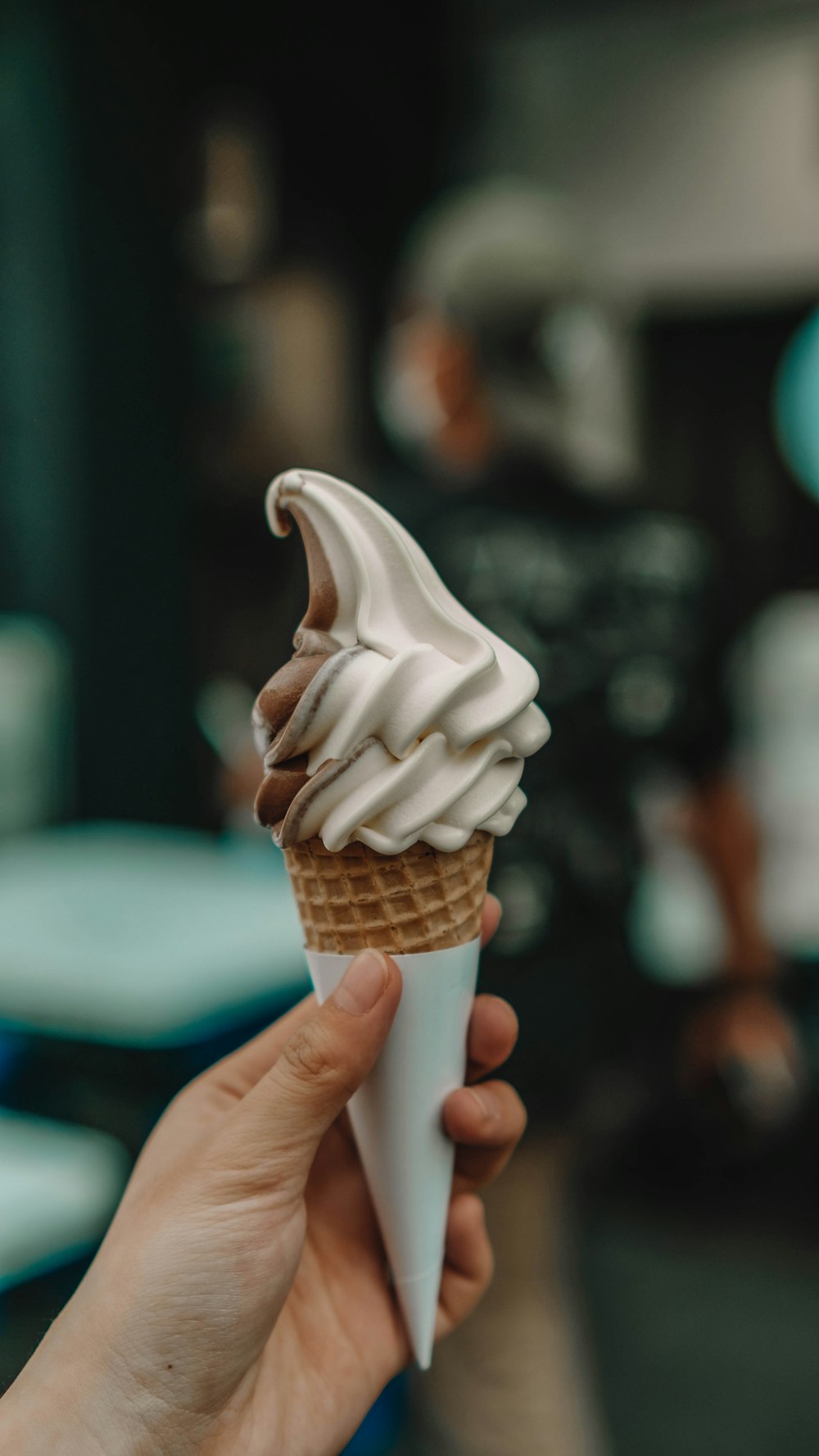 하얀 아이싱이 있는 아이스크림 콘을 들고 있는 손