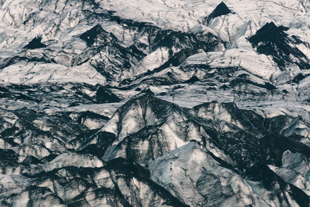 an aerial view of a mountain range covered in snow