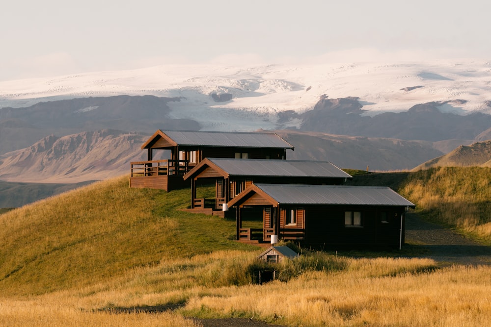 a group of cabins sitting on top of a lush green hillside