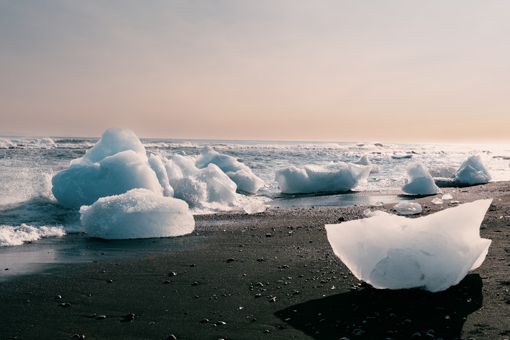 an iceberg on a beach near the ocean
