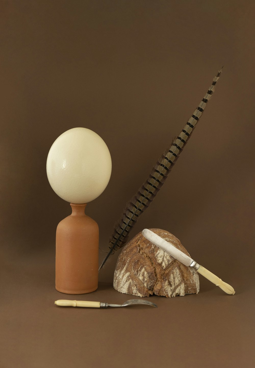 a pair of scissors and a feather on a brown background