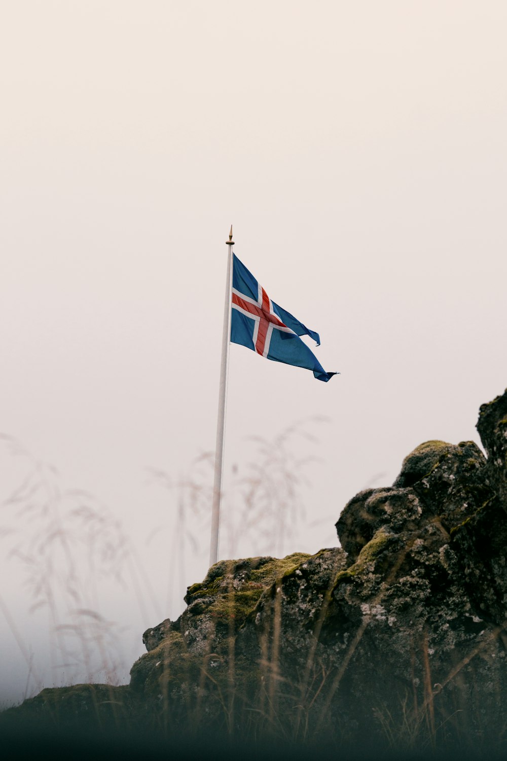 a flag is flying on top of a rock