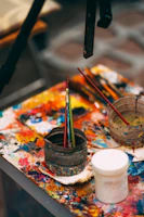 Bright splashes of paint and brushes arranged on a lively workspace