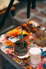 A vibrant artist’s workspace with colorful canvases and brushes.