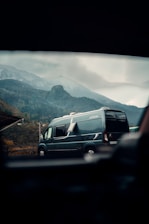 A spacious Hiace van parked in a scenic area with mountains in the background.